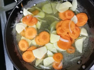 胡萝卜浓汤意面,放入胡萝卜和土豆炒一会，加入水，煮软
