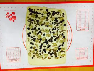 最爱面包➕新疆三果大列巴,铺上三果，其中一边留2～3厘米左右不放三果，留做封边粘合。 核桃仁的大小不宜太大，太大了卷的不紧，我用的核桃仁大小是核桃的四分之一大小。