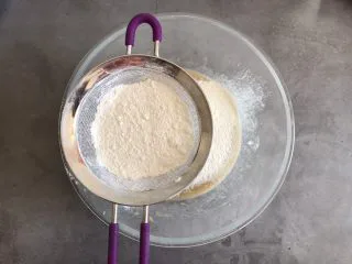 香蕉巧克力豆蛋糕,筛入低筋面粉和泡打粉，翻拌均匀看不见干面粉即可