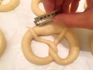 危险与美味并存一一德国碱水包,烤箱预热200度。捞出的普雷结放置10分钟后用锋利的刀片在上面割一小口子（小心手哦）