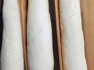 当主食一次可以吃三个的法棍面包,盖上湿布再次放入烤箱发酵半小时。用油纸间隔开,这样发酵的时候基本形状不会变。