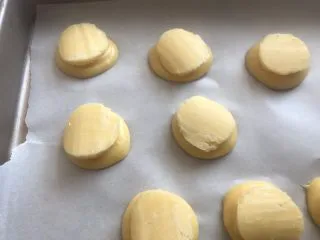 网红草莓脆皮泡芙,把切好的酥皮片盖在上面，放入提前预热好的烤箱上下火180度烤20分钟转150度在烤10分钟即可