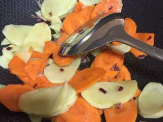 奶油胡萝卜汤,加入胡萝卜片，土豆片，香叶翻炒片刻。