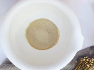 当主食一次可以吃三个的法棍面包,将酵母倒入装了温水的搅拌盆里,静置五分钟让酵母活化一下,直到完全溶解。