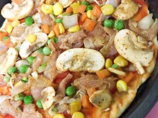 小白也会的奥尔良烤鸡腿披萨 「8寸薄脆版」,然后把鸡肉洋葱还有蘑菇玉米，小西红柿那些料铺盖一层，不要太多，否则不好熟了。