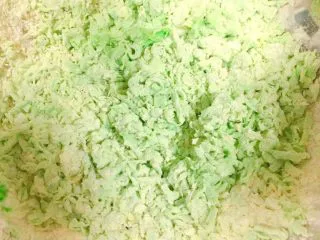 马卡龙色 高颜值汤饺系列@@ 猪肉大葱馅●麦穗饺,然后，我们把蔬菜汁，最好是温的，35度左右的，用左手滴滴点点的浇进刚才备用的有鸡蛋有盐的面里，用右手扒拉，扒拉这个词的意思，就是在菜汁滴下去的附近，搅动面，让面全部成小絮状，如图。哪里干滴哪里，扒拉哪里就对了。因为俩个手都用上了，没办法拍。就拍完成的样子了。