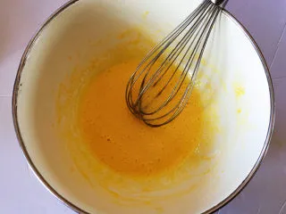 红豆抹茶巧克力慕斯,一次冲入两个蛋黄中，快速搅拌到微微发白，这一步是用开水给蛋黄杀菌，蛋黄的作用是给慕斯起到柔滑，如果在慕斯中不加入蛋黄，口感会差很多的。