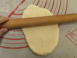 蒜香香肠热狗面包, 擀面杖擀成牛舌形,排出里面的大气泡。