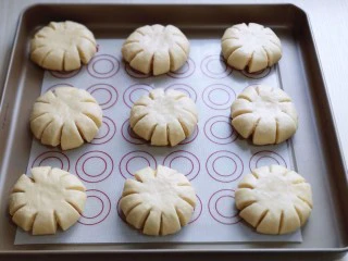 花式椰蓉面包,再用食品剪刀剪出,约1厘米的口子,距离要相等,这样才好看!放入垫有油纸的烤盘中,并间隔距离!