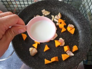 奶香南瓜鸡肉焗饭,放入牛奶，一起炒至牛奶吸变稠。