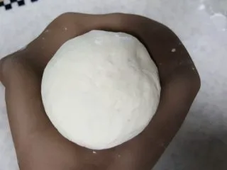 天然酵种割口欧包,面团发酵至原体积的两倍大,有明显的气孔后揉圆,把外皮擀开 ,包好面团。