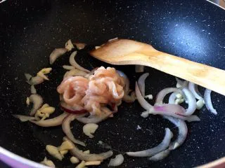 西餐之黑椒鸡丝意大利面,当洋葱香味出来时就可以放入鸡胸肉了，下锅后快速搅拌打散肉丝