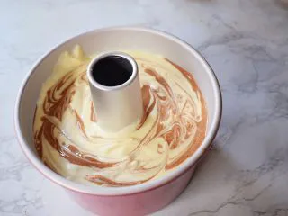 7寸中空双色戚风蛋糕,再用牙签来回划几下,端起模具的两端,轻轻震几下,震出大气泡