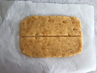 网红咸蛋黄饼干,擀成5mm厚的薄片，横着中间切开