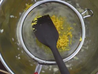 巧克力豆玛格丽特饼干,然后将煮熟的蛋黄过筛到黄油盆子里。用刮刀压按的方式过筛很容易过筛下去的。