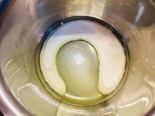 可可波纹戚风蛋糕,首先将玉米油,牛奶以及蛋黄用糖放入容器中。手抽充分搅拌,乳化。