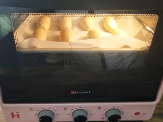 椰蓉奶油面包,把表层喷上一层清水和刷一层蛋液,烤箱预热170°,中层上下温烤25分钟左右,期间加盖锡纸