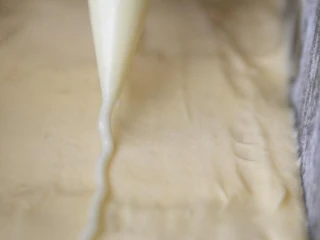 柠檬糖霜磅蛋糕,在麵糊表面的中间，挤一条、或切一条细长的奶油，可帮助烘烤时裂纹比较漂亮