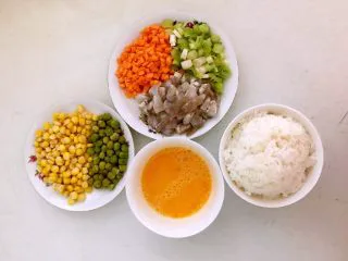 什锦虾仁焗饭,把玉米和青豆用开水烫一下，虾仁和胡萝卜切成小丁，葱切成末，鸡蛋液调匀