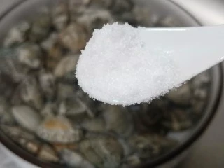 烤箱版【金针菇蒜香烤花蛤】,将花蛤放入淡盐水中、加一勺盐、葱段2根、芝麻油半勺静养2小时使其吐出泥沙。