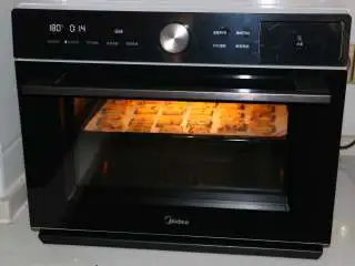 香酥美味蔓越莓饼干,烤箱提前预热，将烤盘放入烤箱中层180度15分钟左右，上色满意即可。