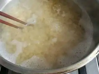 意式番茄蘑菇通心粉,把通心粉在锅里煮开,第一次煮开后加冷水一碗继续煮,并用筷子搅拌防止粘锅底。