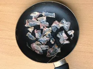 薯条的N种吃法,煎锅放培根,尽量分开些放,毕竟是一片片裹薯条胡萝卜丝的。小火煎。