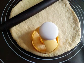 巧克力甜甜圈,将面团擀成厚1厘米左右的面饼,用模具在上面印出甜甜圈形状的饼胚。