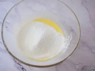 酸奶蛋糕(黄油版),把低筋面粉和玉米淀粉混合后过筛入蛋黄液中