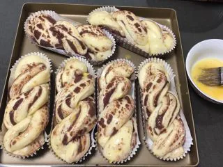 豆沙扭扭面包,发酵完成刷上鸡蛋液,另一盘盖上保鲜膜备用。