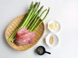 培根“如意”卷,食材准备： 芦笋8-10根 培根300克 橄榄油几滴 黄油30克 黑胡椒粉10克 黑胡椒酱50克 食盐适量 牙签适量