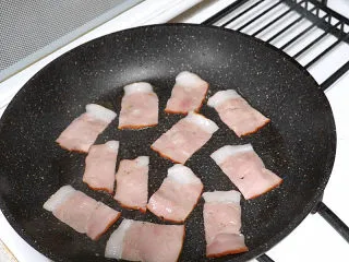 芝滋味浓滴【培根蘑菇白酱意面】,平底锅加热,倒入橄榄油。放入培根两面煎香