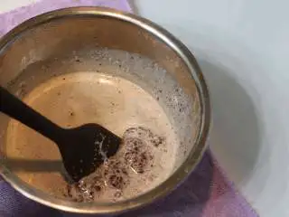 巧克力熔岩杯子蛋糕, 用刮刀同一方向画圈搅拌至顺滑后放凉备用(刚开始搅拌时会是比较渣的状态,正常现象。)