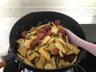 网红~~~抹茶雪花酥,倒入饼干+草莓干+开心果混合物,搅拌。