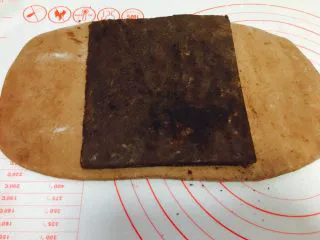 网红脏脏包（开酥版）,取出冷藏的主面团，擀成长方形，大小可以包裹住黄油片即可。主面团与黄油片的软性程度控制在用手可以弯曲即可。