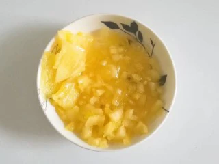 果味长崎纸杯蛋糕,取适量凤梨果肉切成细丁和三角薄片,再拌入适量蜂蜜;