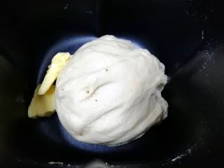 果酱辫子面包,十五分钟以后，面团和好了，加入软化好的黄油，继续“自动和面”十五分钟。
