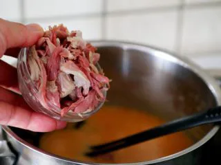 西红柿土豆浓汤,10.当西红柿土豆糊煮开时,加入刚才撕的肘子瘦肉丝。