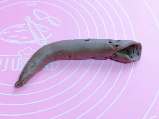 懒人必做~巧克力贝果,再卷成长条状,搓成圆柱形,一边尖,一边压扁,如图。