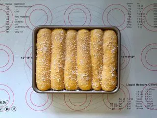 南瓜豆沙排包,16、表面刷上一层牛奶液,撒上椰蓉。