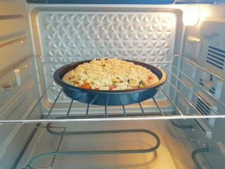 火腿彩蔬披萨,送入预热好的烤箱。