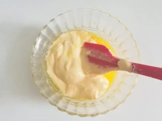 果味长崎纸杯蛋糕,取少许蛋糊放入黄油牛奶混合液中翻拌均匀;