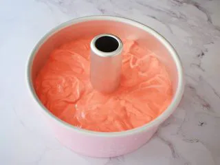 八寸中空红丝绒戚风蛋糕,把拌匀的蛋糕糊倒入学厨8寸的中空模具中,端起模具的两端,指拇按住中空柱上空,轻轻震几下,震出大气泡