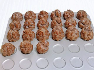 巧克力奶油泡芙,戴上隔热手套取出烤盘，放旁边晾凉。