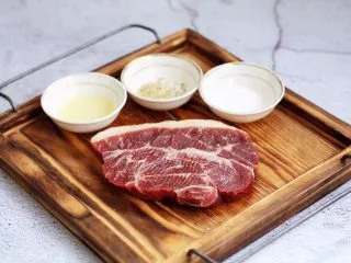 红酒黑胡椒牛排,在板腱牛排两面撒上少许的海盐,盐放少了也没关系,吃的时候再撒些盐也可以,撒少许的黑胡椒碎,一点点就可以,黑胡椒碎一定要少,否则煎的时候糊了发苦,再在板腱牛排两面抹上少许的橄榄油,静置15分钟。