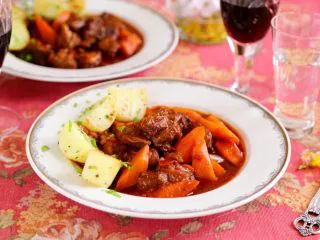#食二星座#法式红酒炖牛肉 Boeuf Bourguignon,13.红酒炖牛肉和土豆盛到西餐盘中，还有红酒，这就是地道的法式红酒炖牛肉。 当然了你想配面包、米饭，或意面、面条也是可以的，这道法式炖牛肉与我们平常的红烧牛肉是极其相似的。 