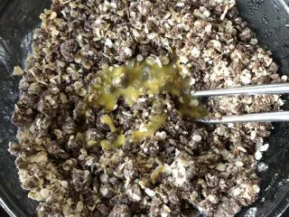 燕麦巧克力能量球,倒入蛋液，搅匀，这时候的面团程松散状，但也比较湿润，用手一捏就能捏出小球。 