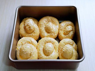 松软老式小面包,取出发酵好的面包胚，是原来的1.5倍大，刷上蛋液，撒上白芝麻。