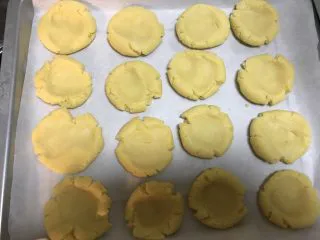 酥掉渣的桃酥,中间压扁，放到油纸上，烤箱180度预热10分钟。