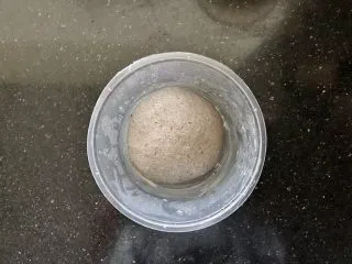 黑芝麻吐司(一次发酵）,把面团放入碗中盖上保鲜膜室温下松弛20分钟。(注意是松弛不是发酵）